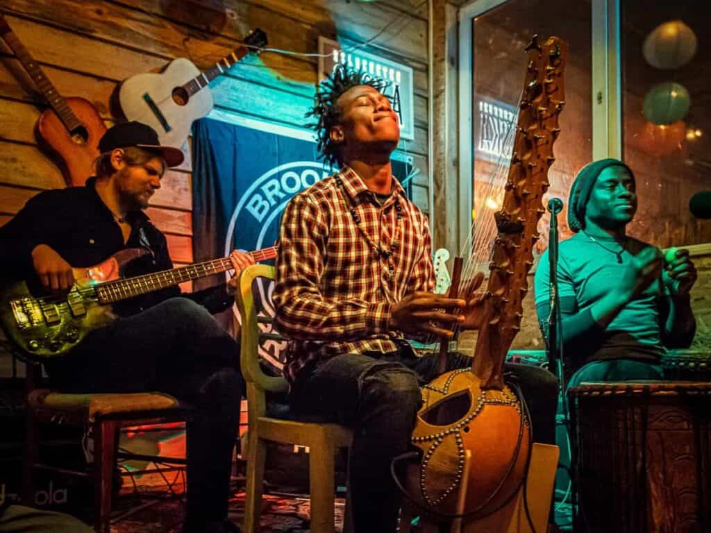 Trzech muzyków grających na żywo w klubie muzycznym z instrumentami.